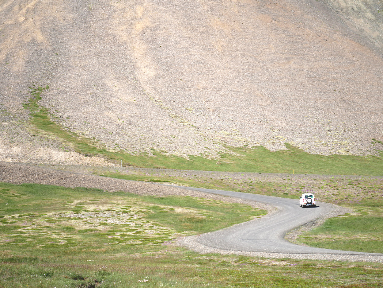 white jeep going up a hill