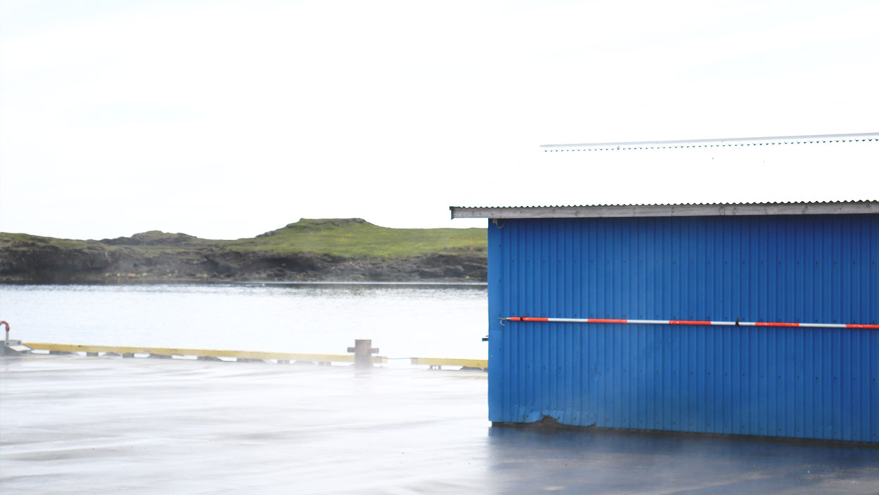 blue shed in the harbor of djúpivogur